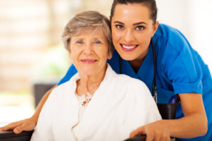 smiling caregiver assisting old woman on the wheelchair