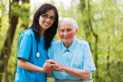 caregiver assisting old woman to walk